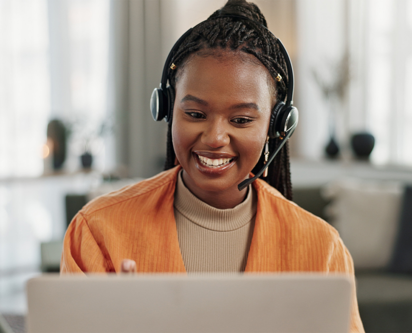 Smiling Woman On Laptop Wearing Headset