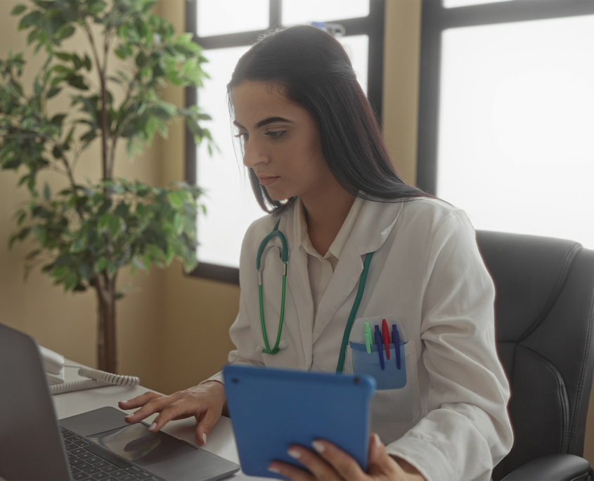 Doctor Wearing A Stethoscope And Using Tablet And Laptop